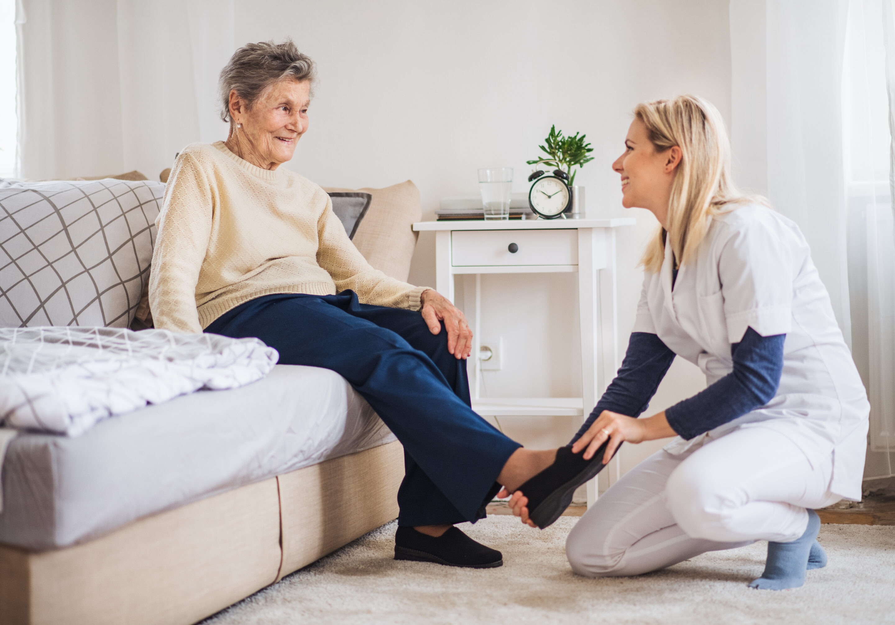 Caregiver helping elderly client with personal care in comfortable home setting