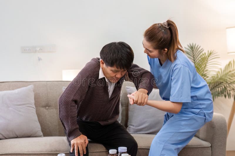Professional caregiver helping elderly client in comfortable home living room setting